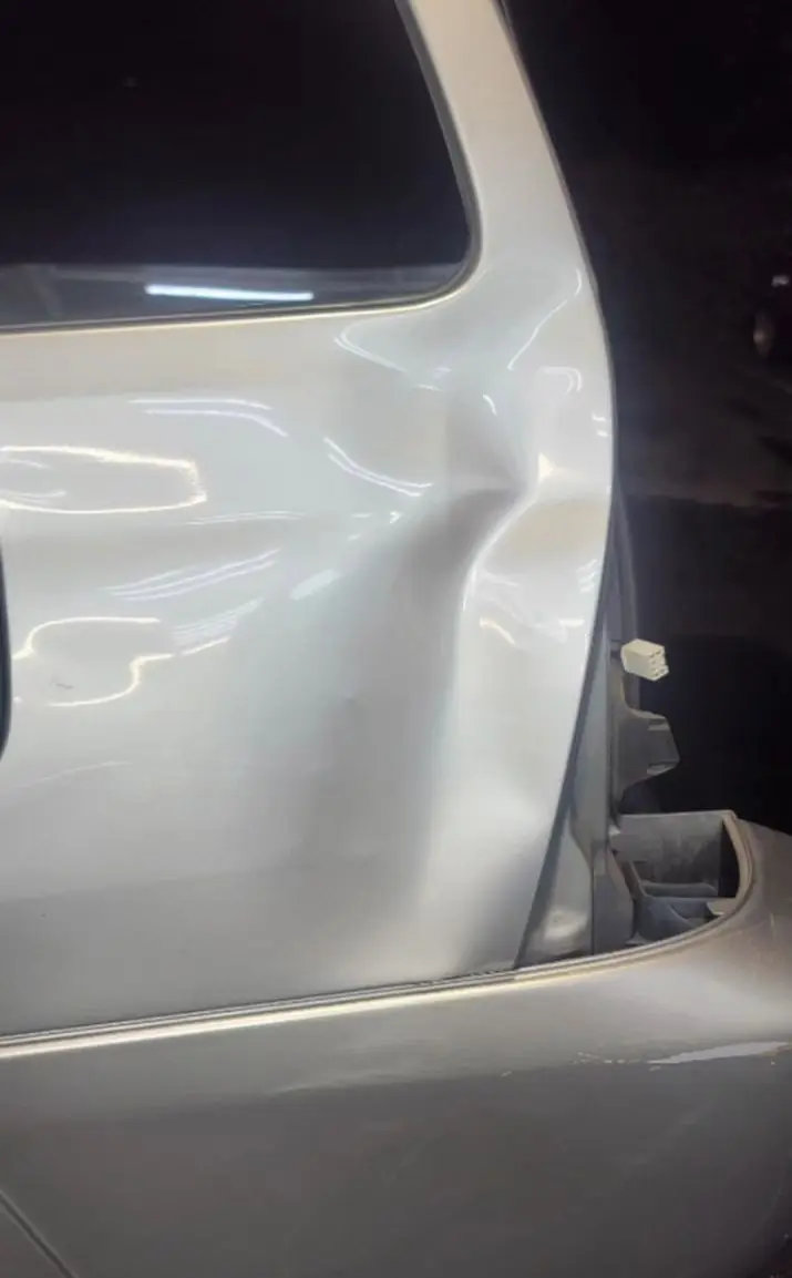Before: Crushed quarter panel on a silver Toyota 4Runner