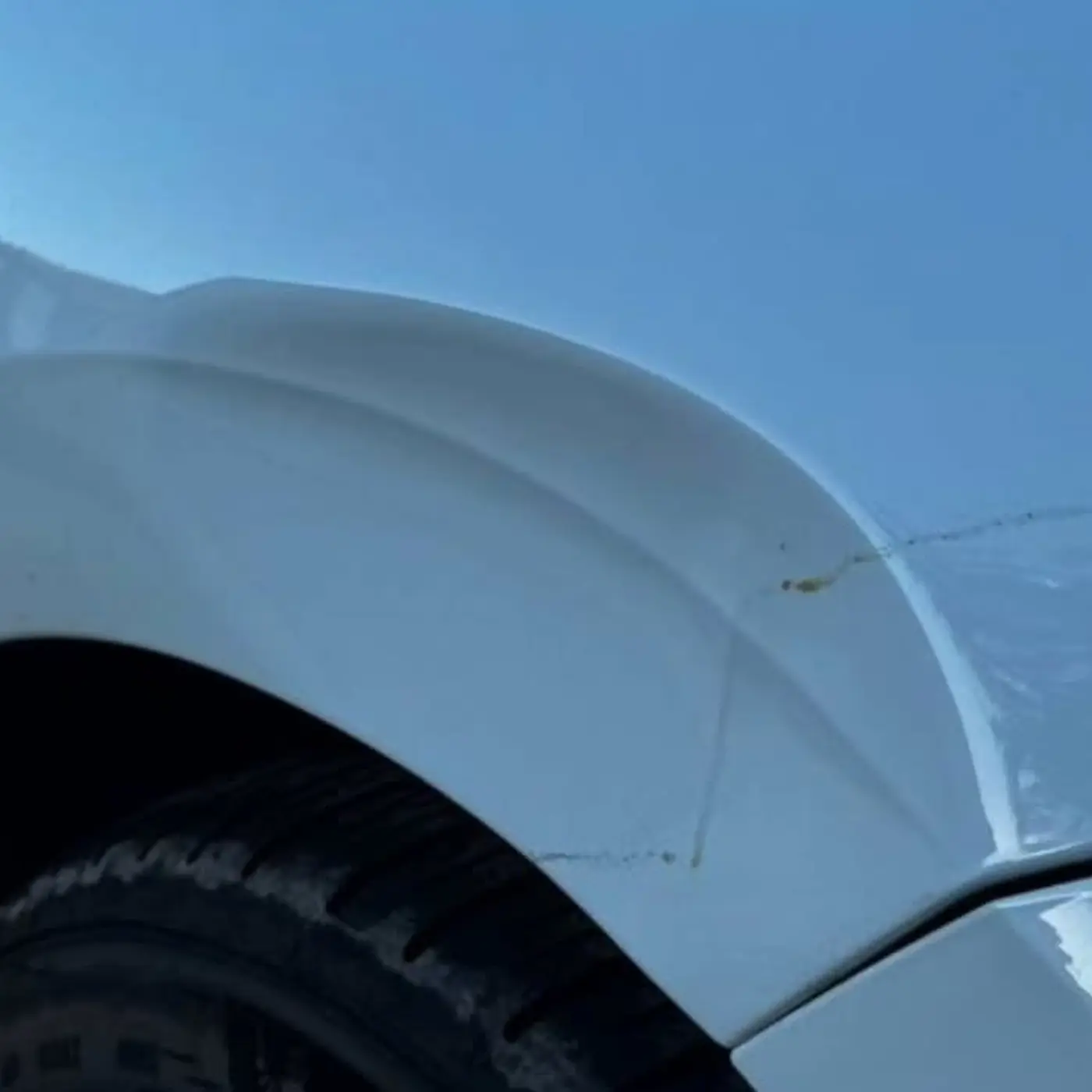 Before: Creased front fender on a white Lexus