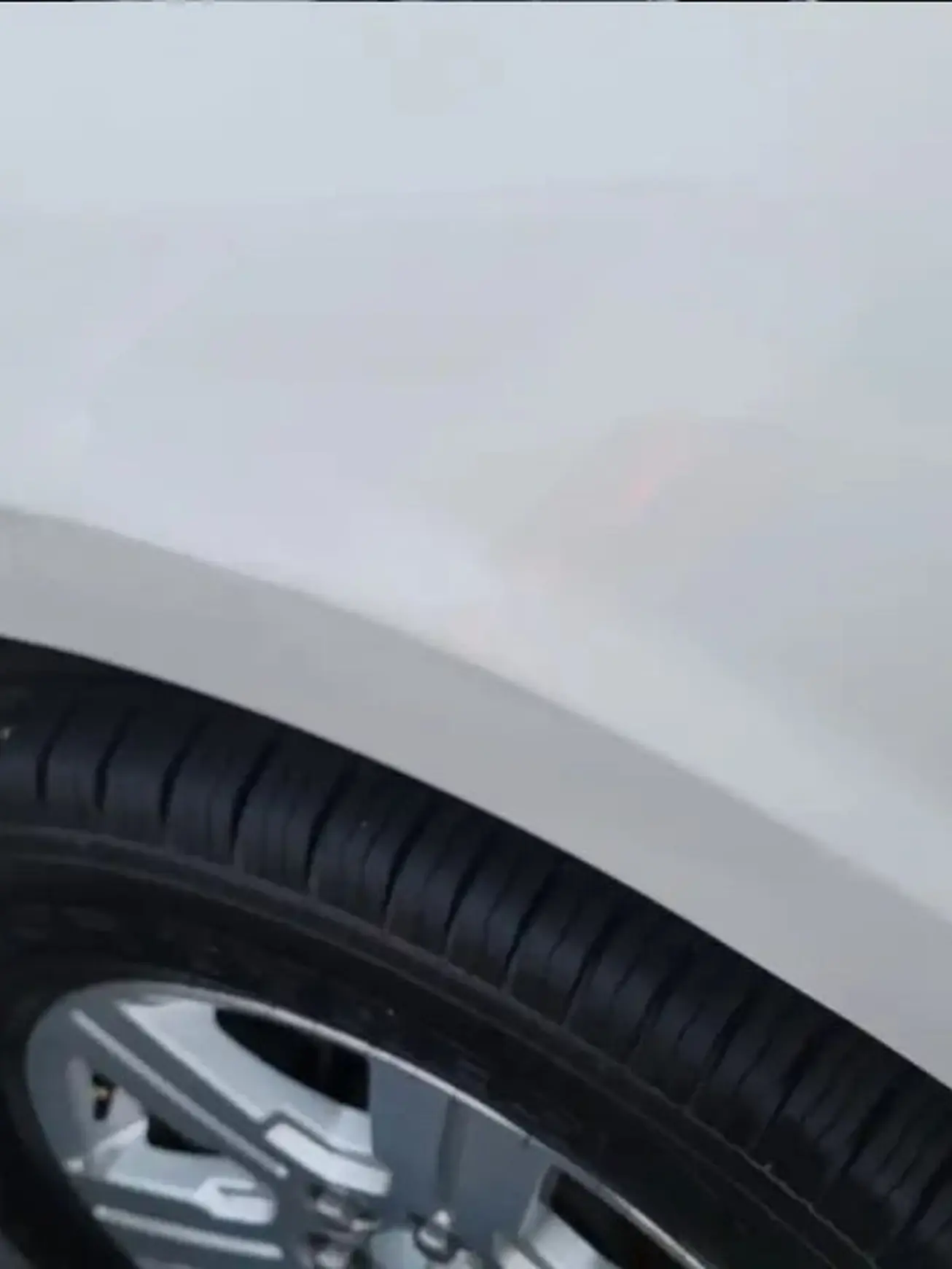 After: Fender dent above the wheel on a white Volkswagen